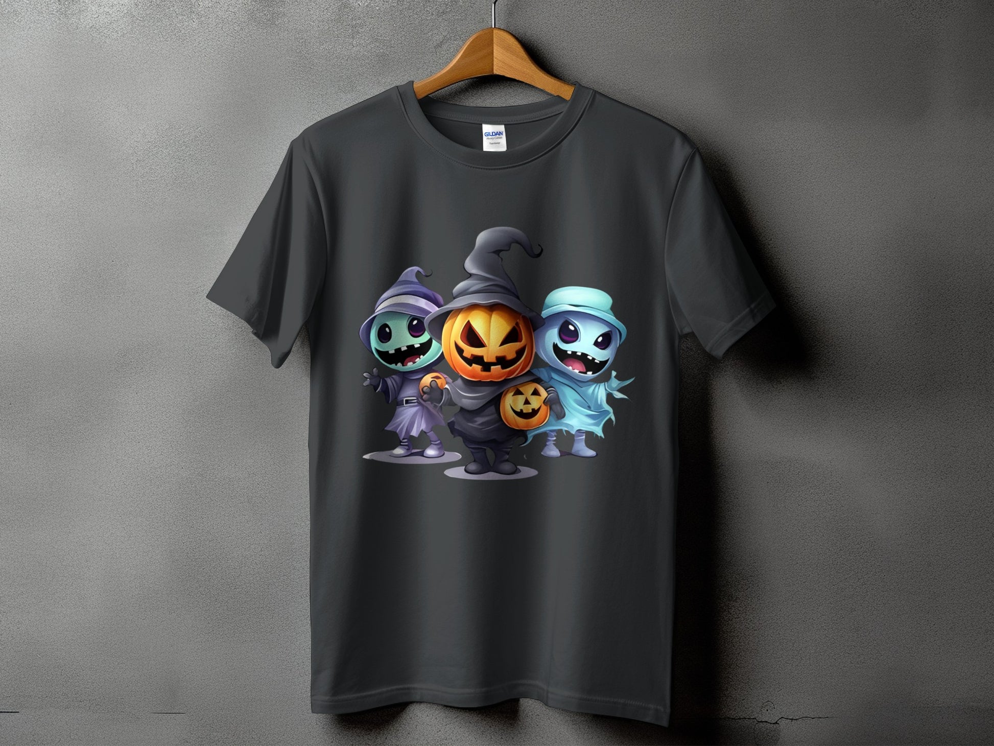 Dark t-shirt with a graphic of three cartoon Halloween characters: pumpkin, witch, and ghost.