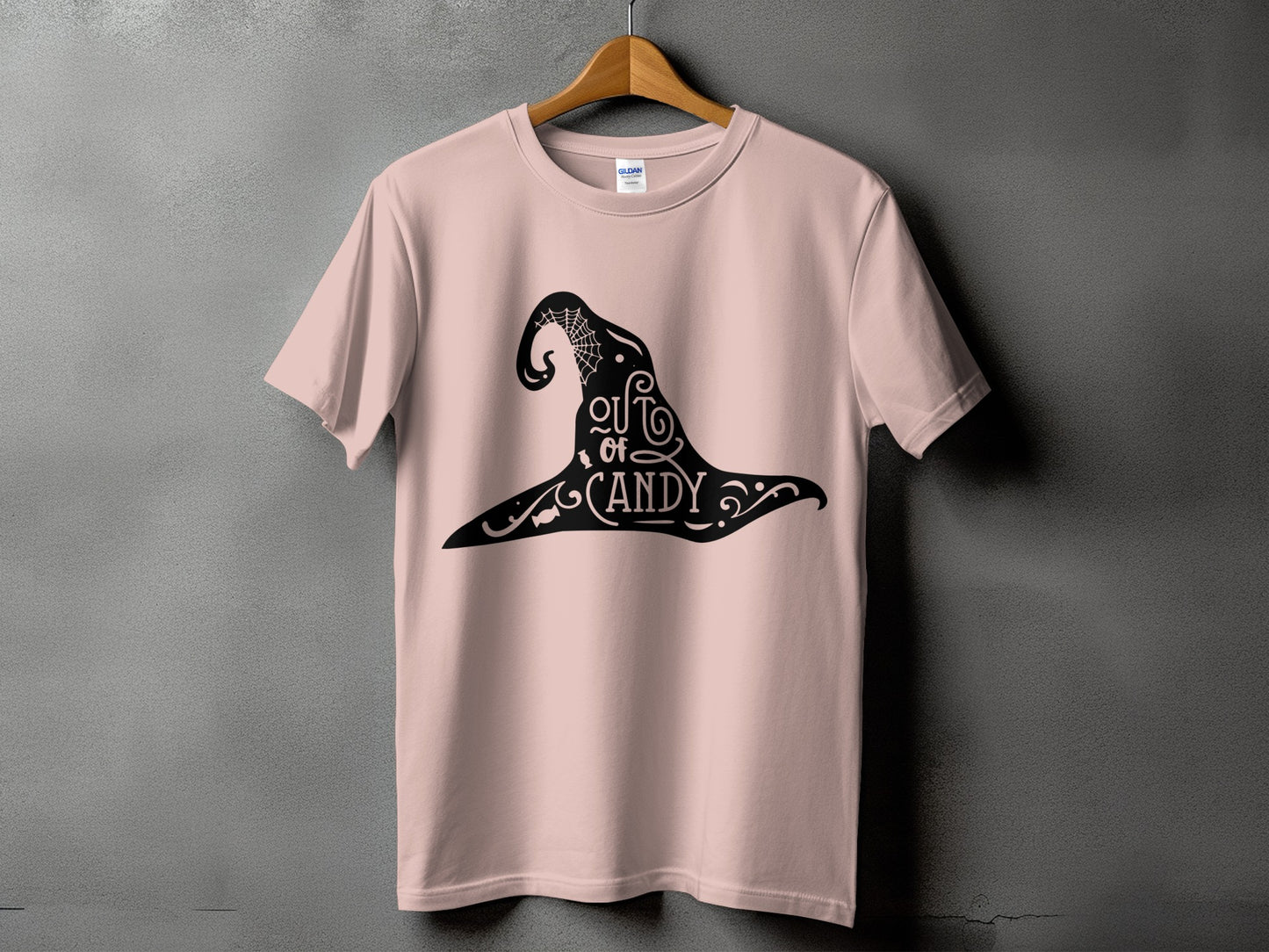 Pink t-shirt with black witch hat graphic that says "out of candy".