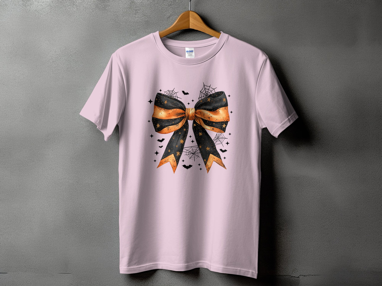 Pink t-shirt with a large black and orange Halloween bow graphic.