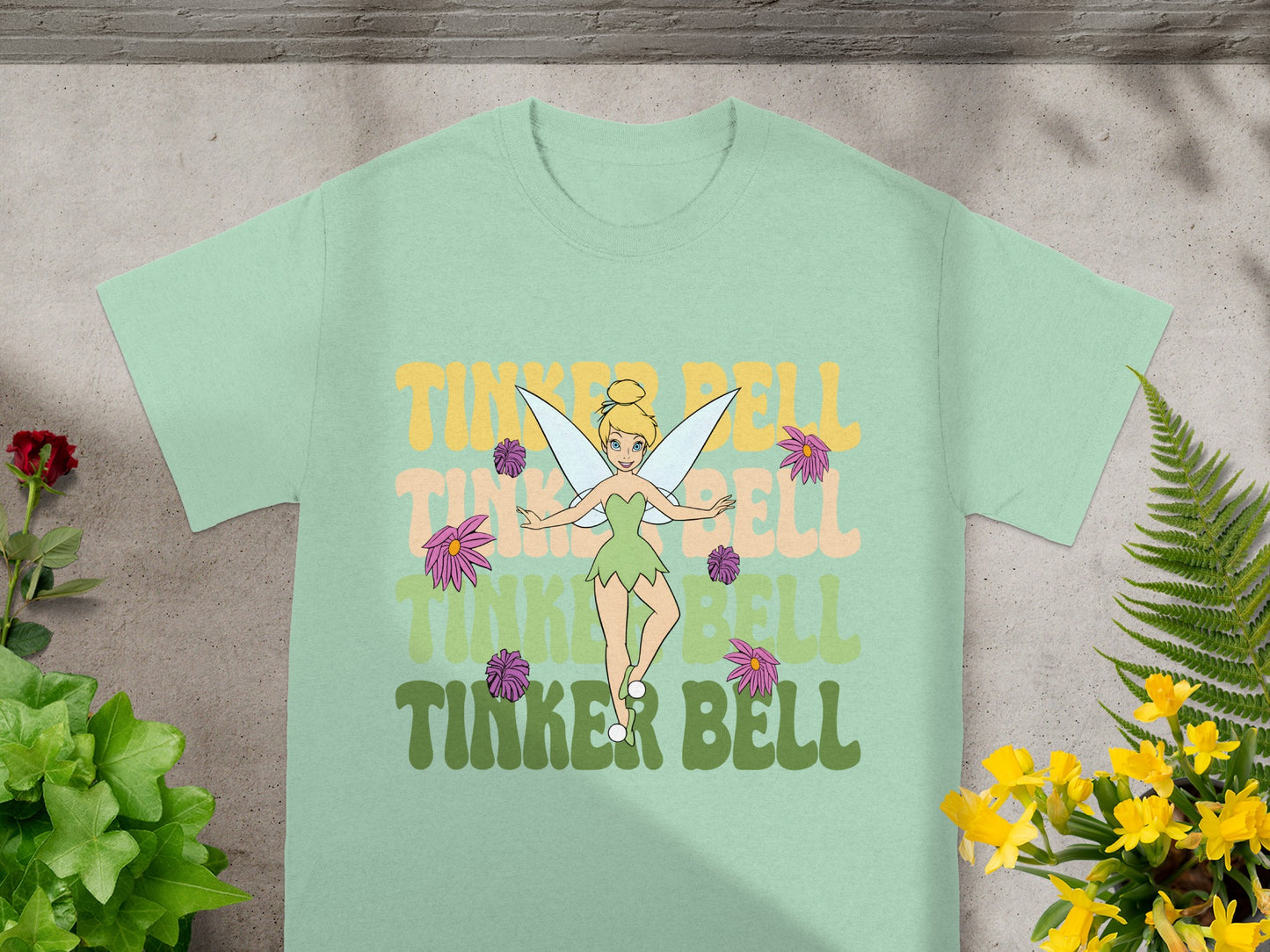 Tinker Bell t-shirt with pastel gradient text and floral accents.
