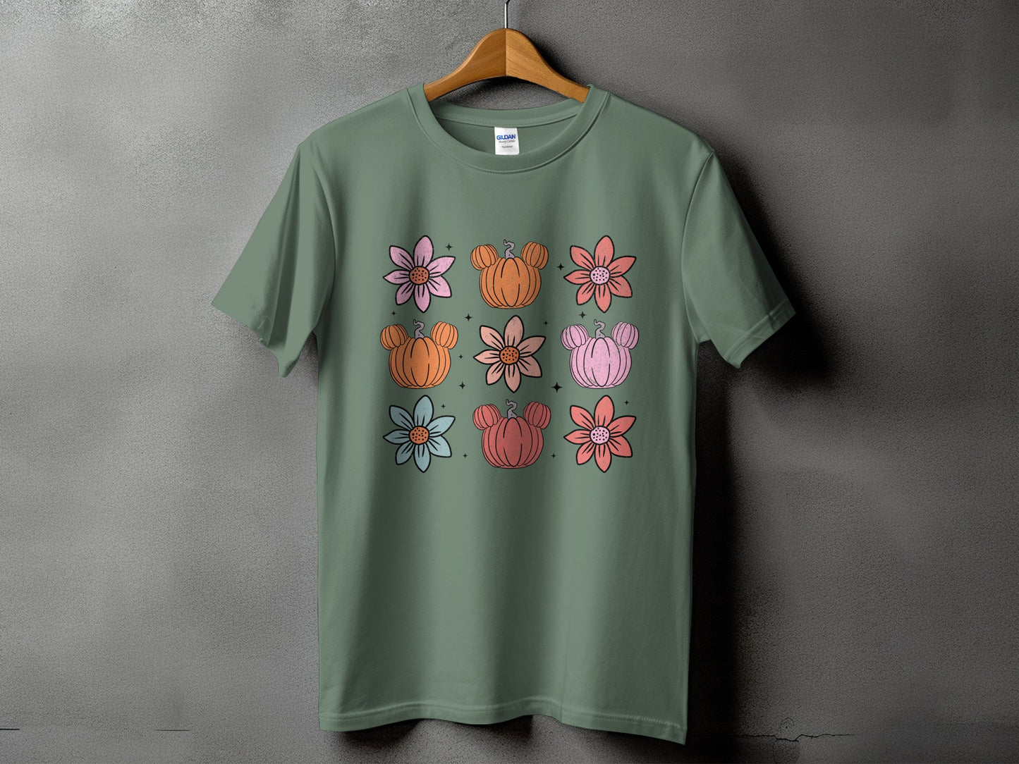 Green t-shirt with a repeating pattern of flowers and Mickey Mouse pumpkins.