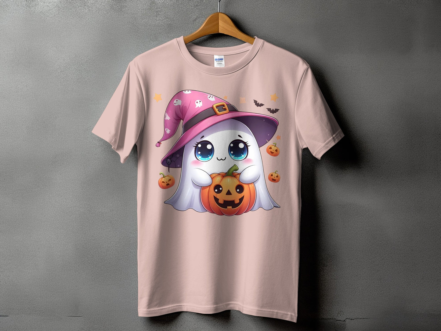 Pink t-shirt with ghost in witch hat holding pumpkin and surrounded by pumpkins.