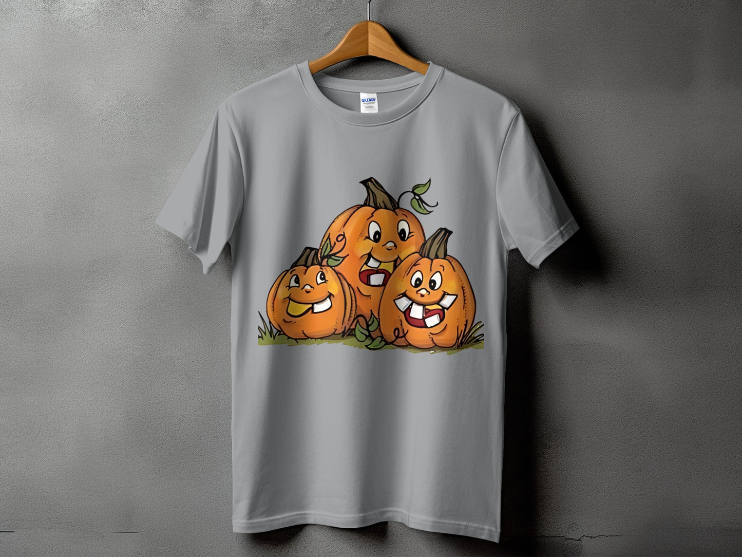 Gray t-shirt with a cartoon drawing of three happy pumpkins with leaves.