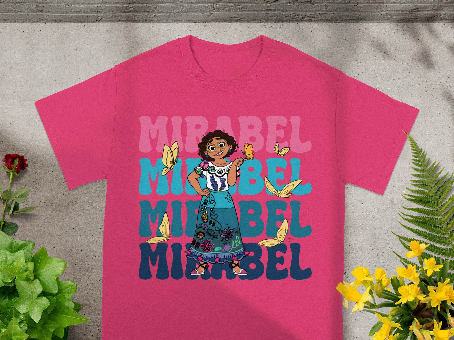 Mirabel from Encanto on a pink t-shirt with butterflies and colorful text.