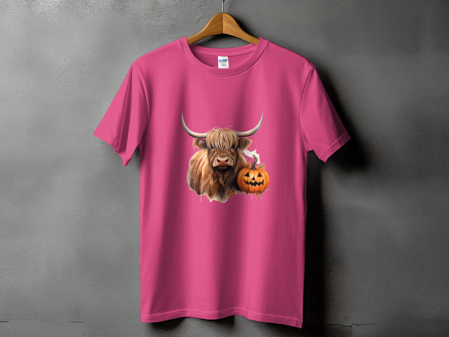 Pink t-shirt with a Highland cow and jack-o'-lantern graphic.