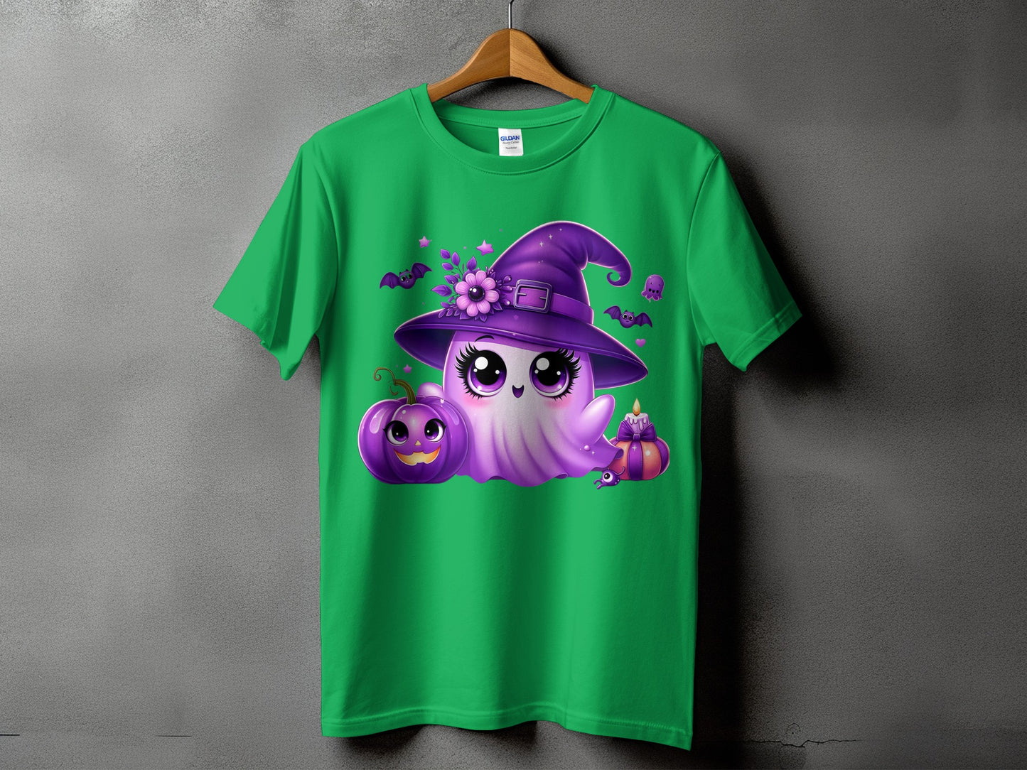 Green t-shirt with a cute purple ghost wearing a witch hat and holding Halloween decorations.