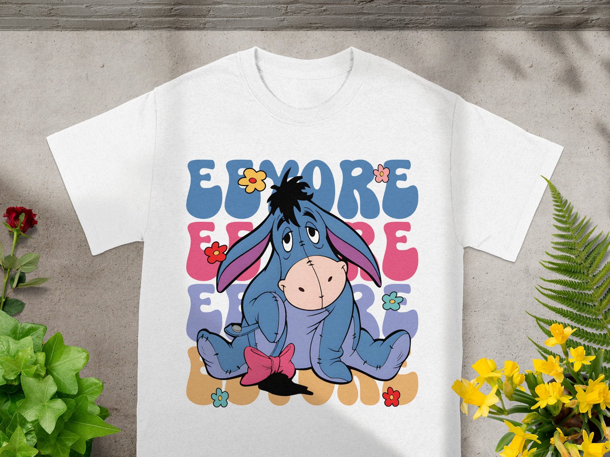 Eeyore with colorful text, sitting on a t-shirt.