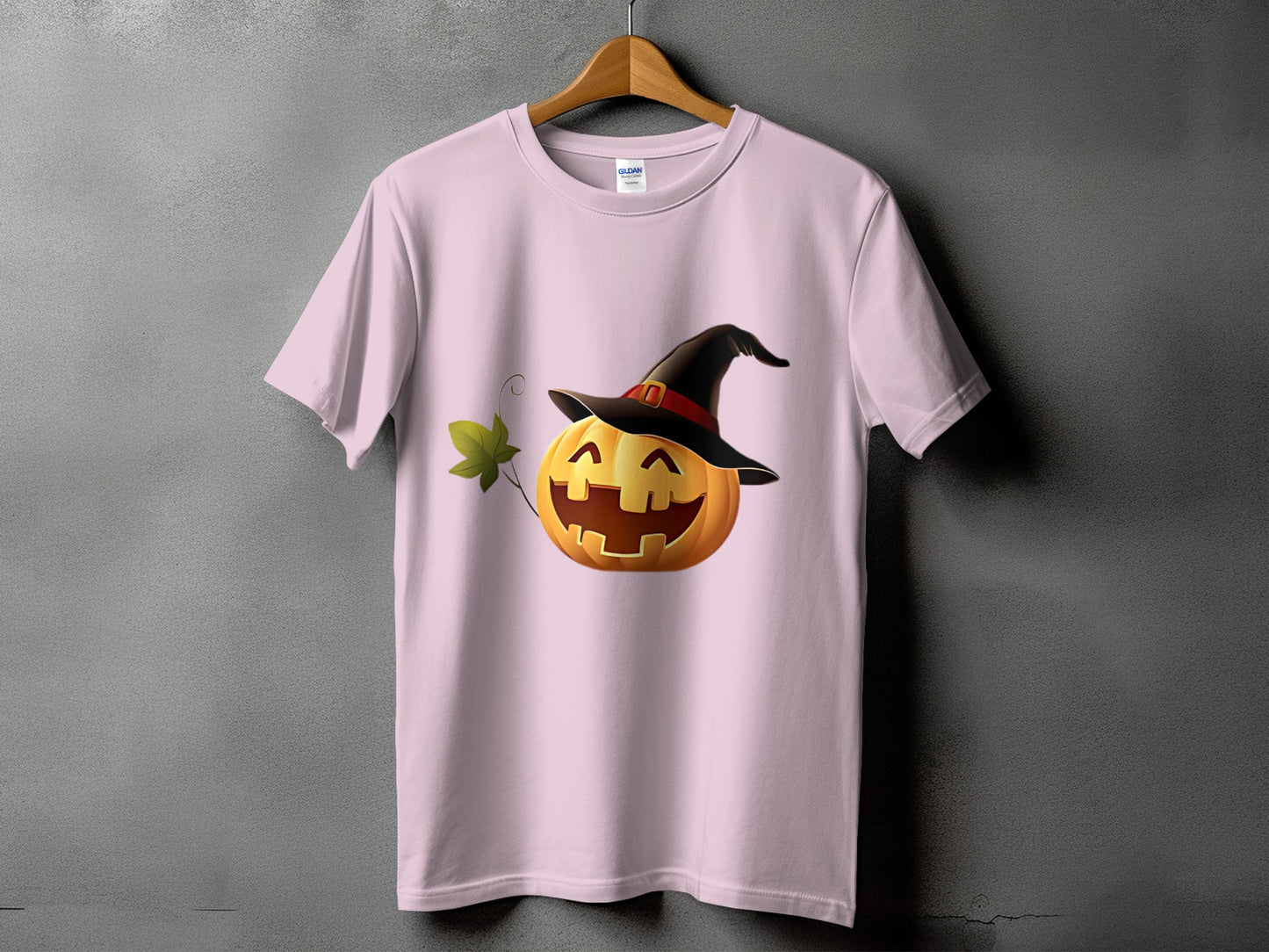 Pink t-shirt with a smiling jack-o'-lantern wearing a witch's hat.