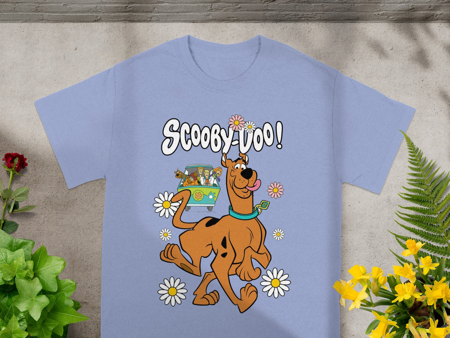 Scooby-Doo with the Mystery Machine and flowers on a light purple t-shirt.