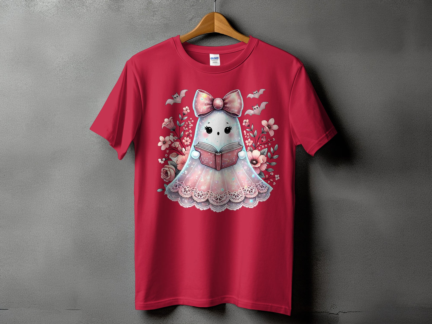 Red t-shirt with a cute ghost reading a book surrounded by flowers and bats.