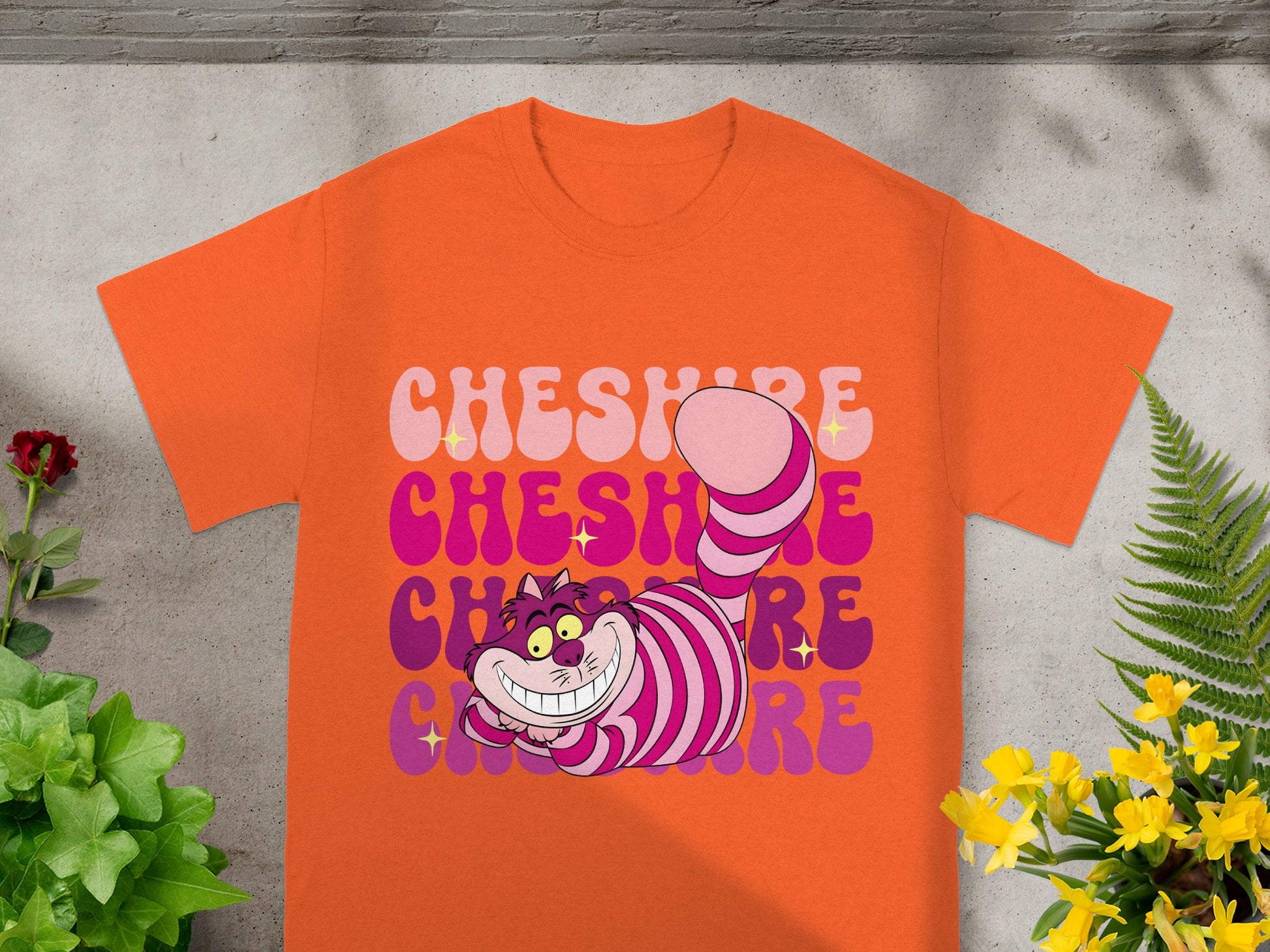 Orange t-shirt with "Cheshire" text and grinning striped cat design.
