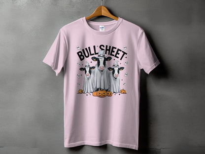 Pink t-shirt with three cows dressed as ghosts with pumpkins and the text "BULL SHEET".