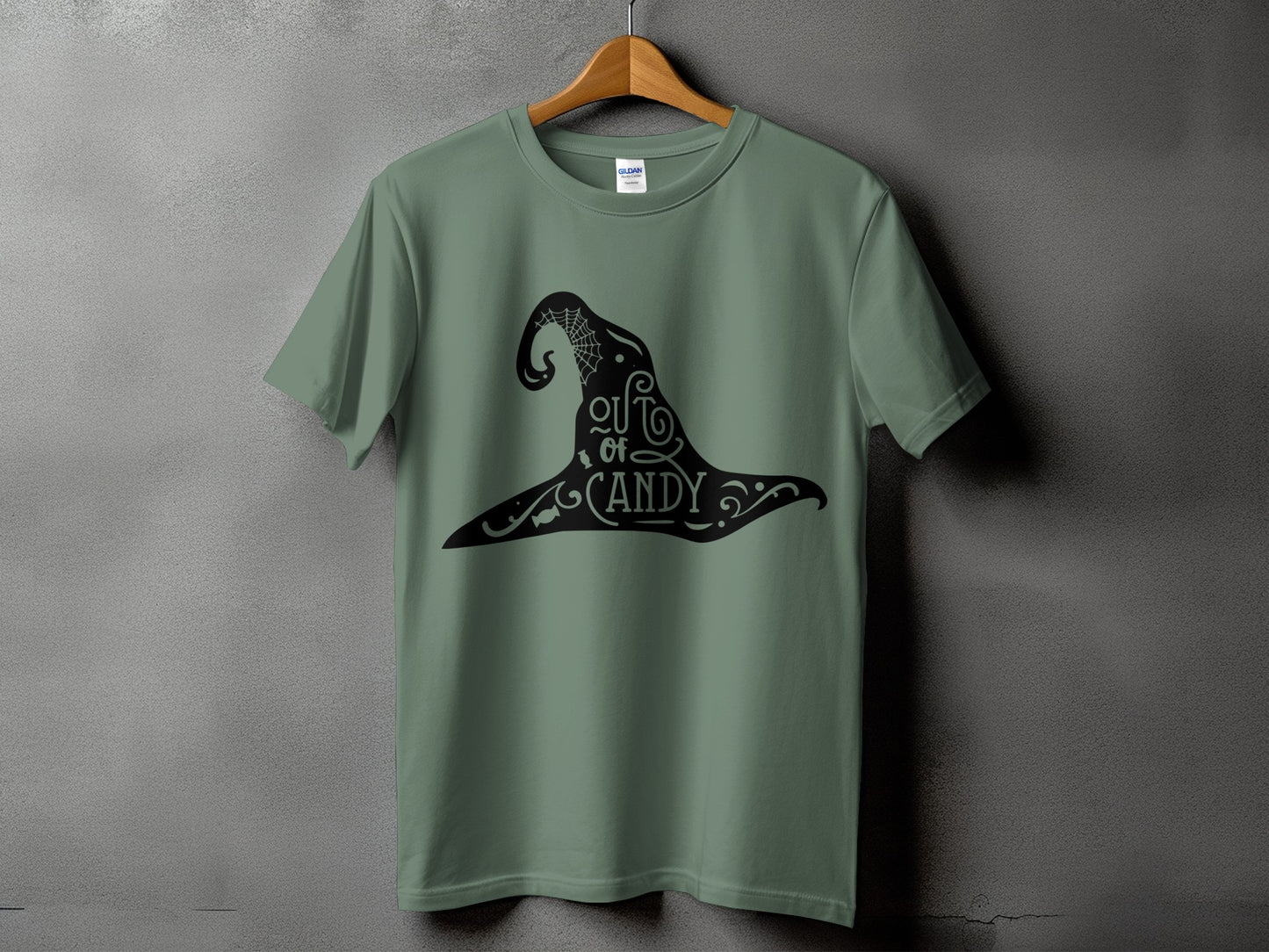 Green t-shirt with black witch hat graphic saying "out of candy"