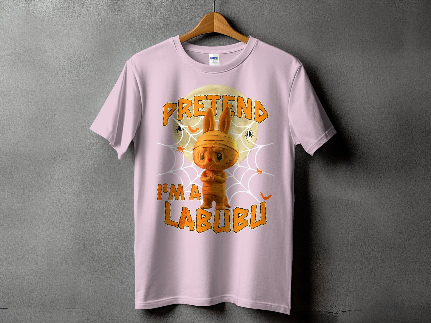 Pink t-shirt with Halloween graphic of mummy Labubu character and text "PRETEND I'M A LABUBU".