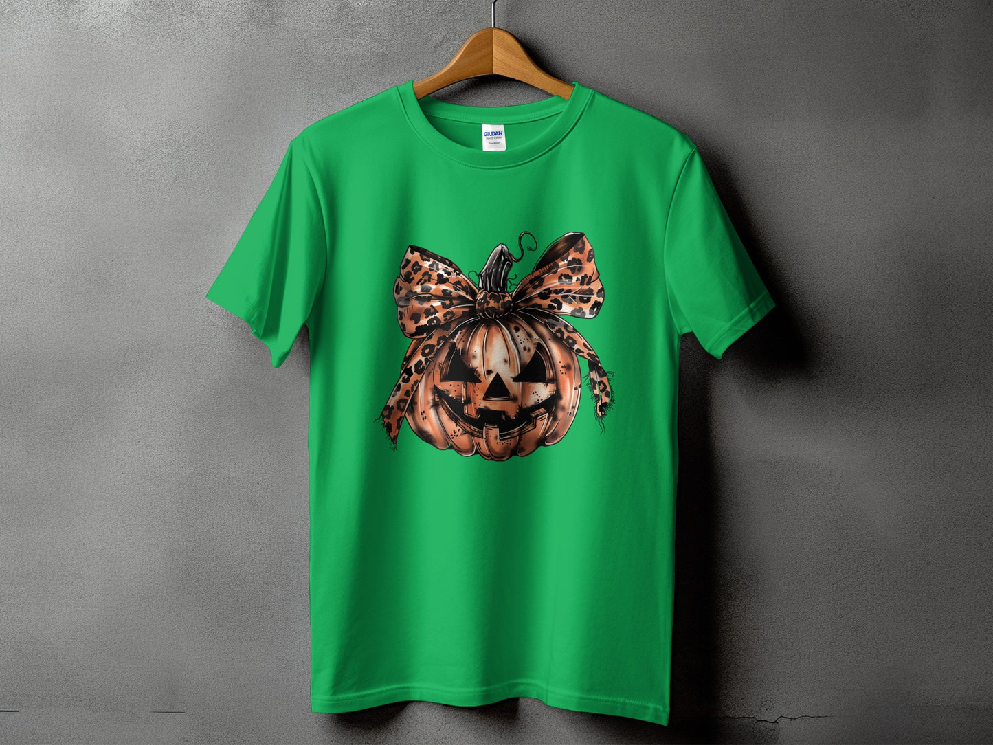 Green t-shirt with a jack-o'-lantern graphic and a leopard print bow.