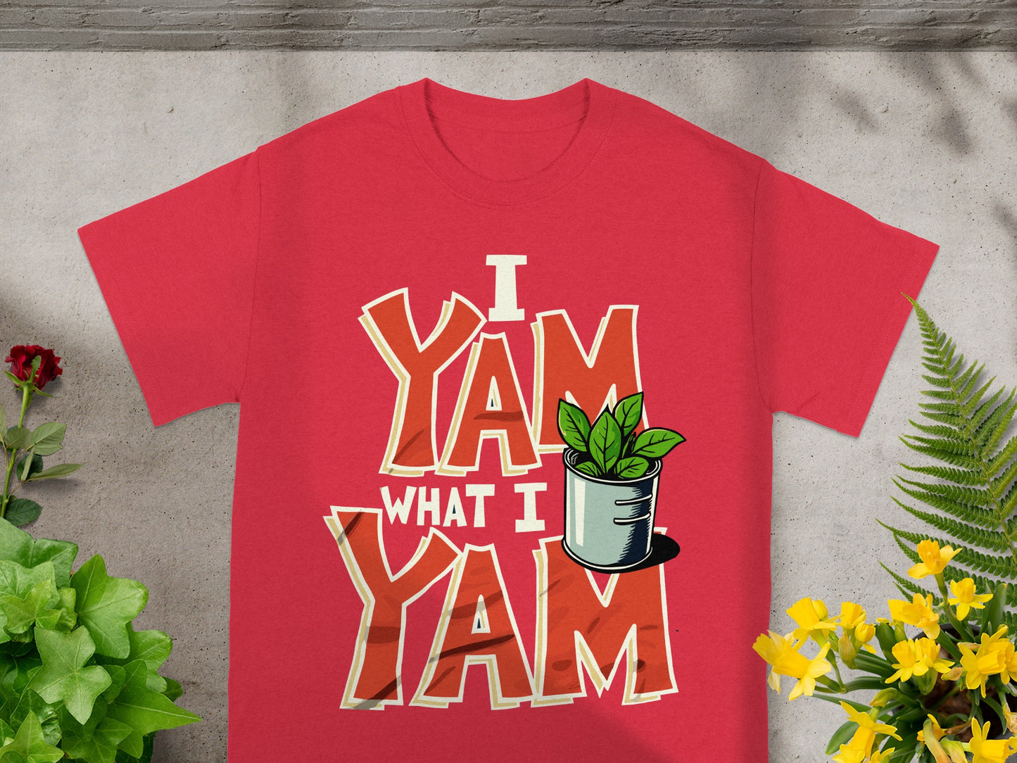 Red t-shirt with "I Yam What I Yam" text and a potted plant.