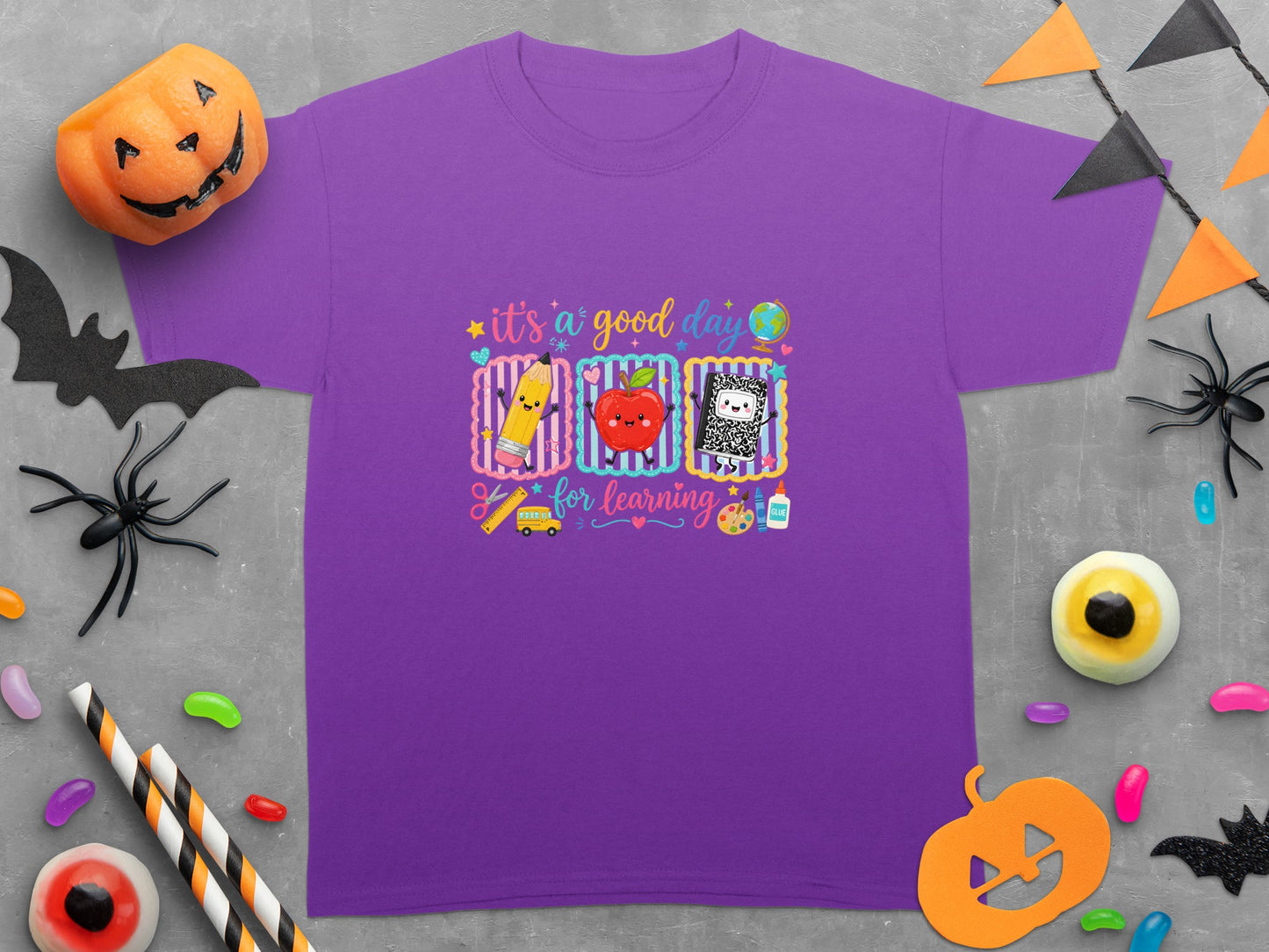 Purple t-shirt with "it's a good day for learning" graphic featuring school supplies.