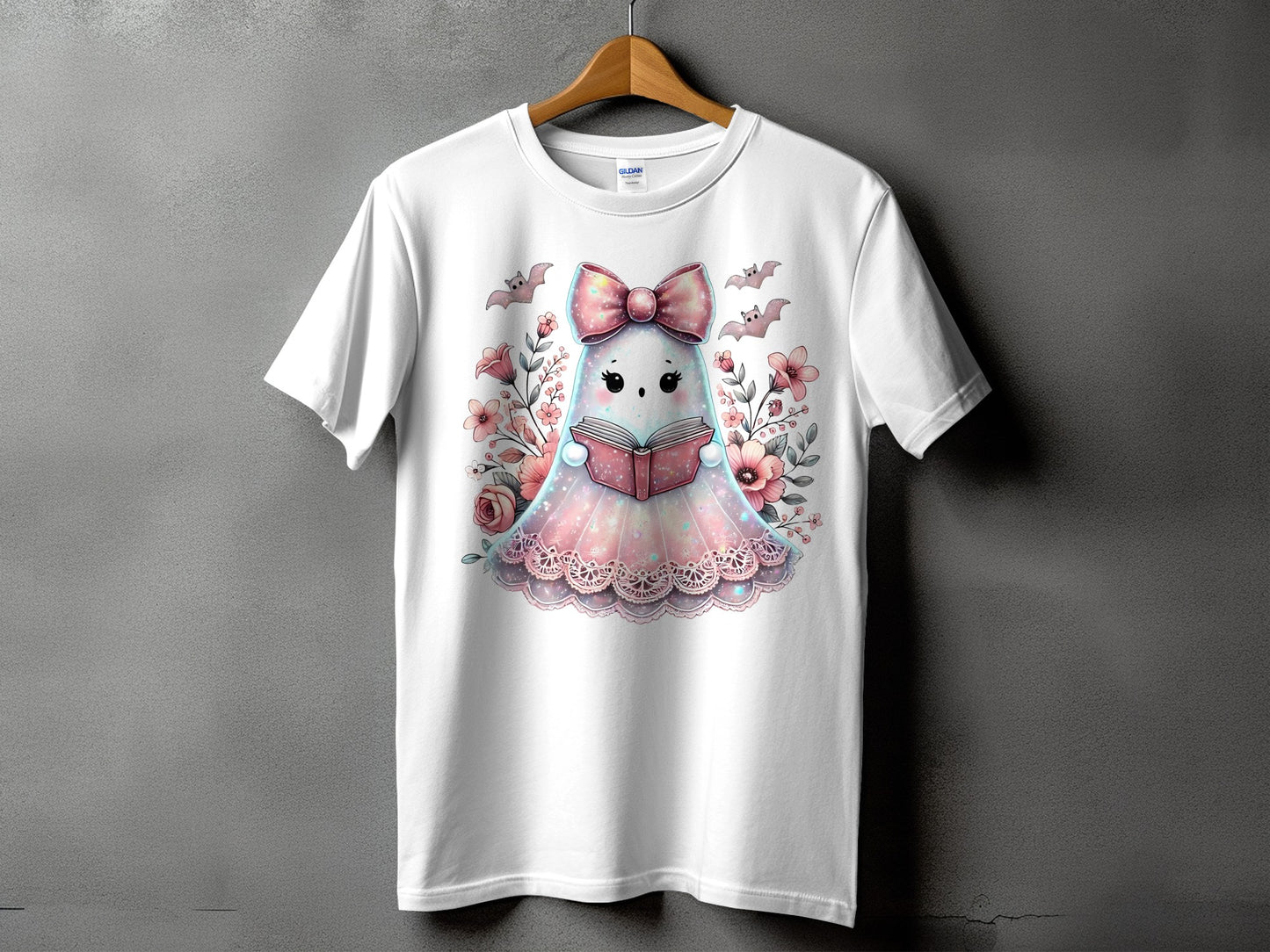 White t-shirt with a cute ghost reading a book, surrounded by flowers and bats.