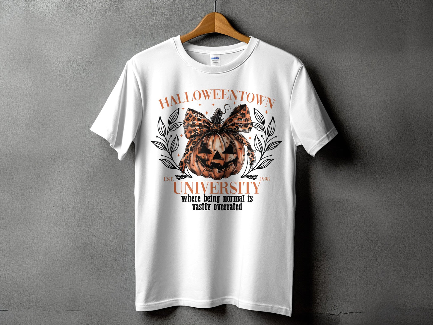 White t-shirt with a Halloween graphic featuring a pumpkin and text.