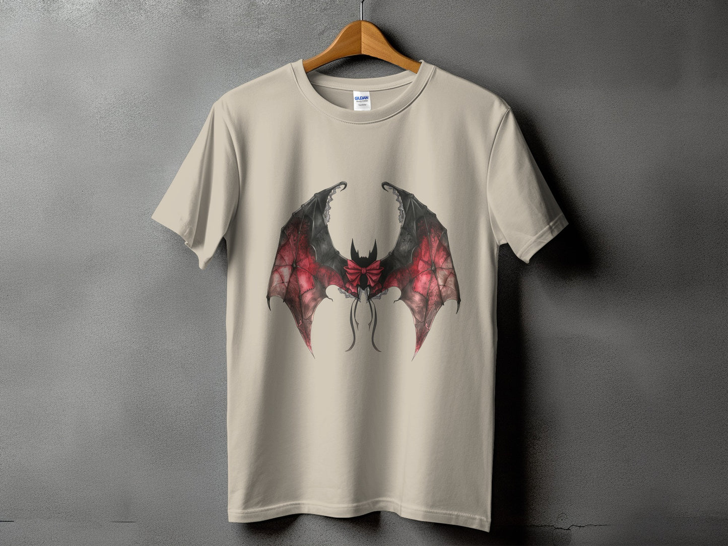 Beige t-shirt with a red and black bat wing design and a bow.
