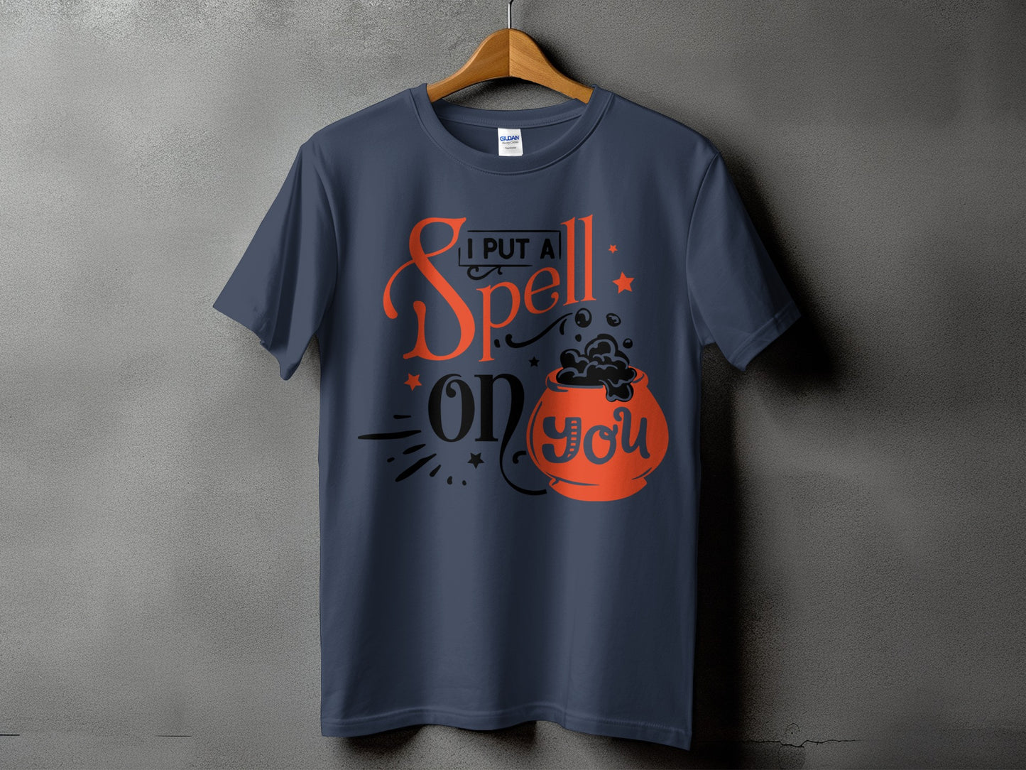 Dark blue t-shirt with orange text and cauldron graphic that reads "I PUT A Spell on you".