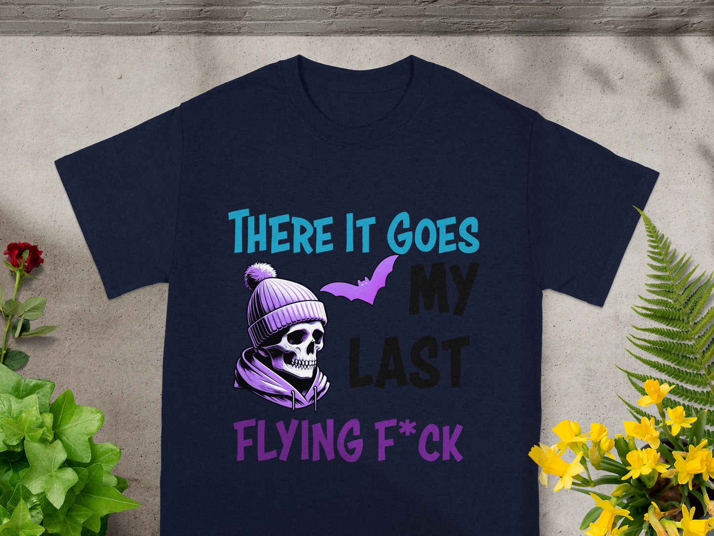 Dark navy t-shirt with a skull wearing a beanie, a bat, and the text "THERE IT GOES MY LAST FLYING F*CK".