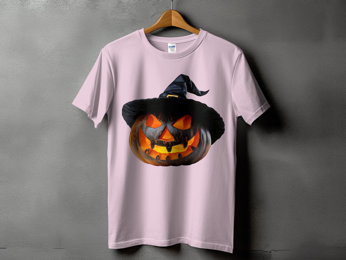 Pink t-shirt featuring a carved Halloween pumpkin wearing a witch hat.