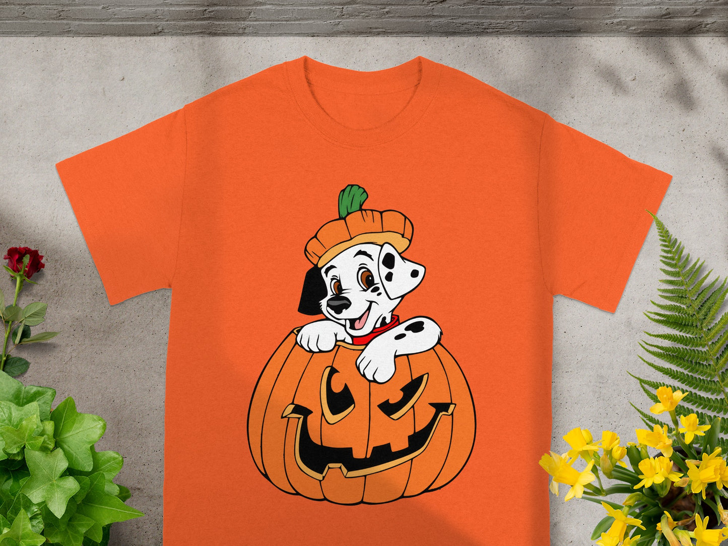 Dalmatian puppy wearing a pumpkin hat peeking out of a jack-o'-lantern.