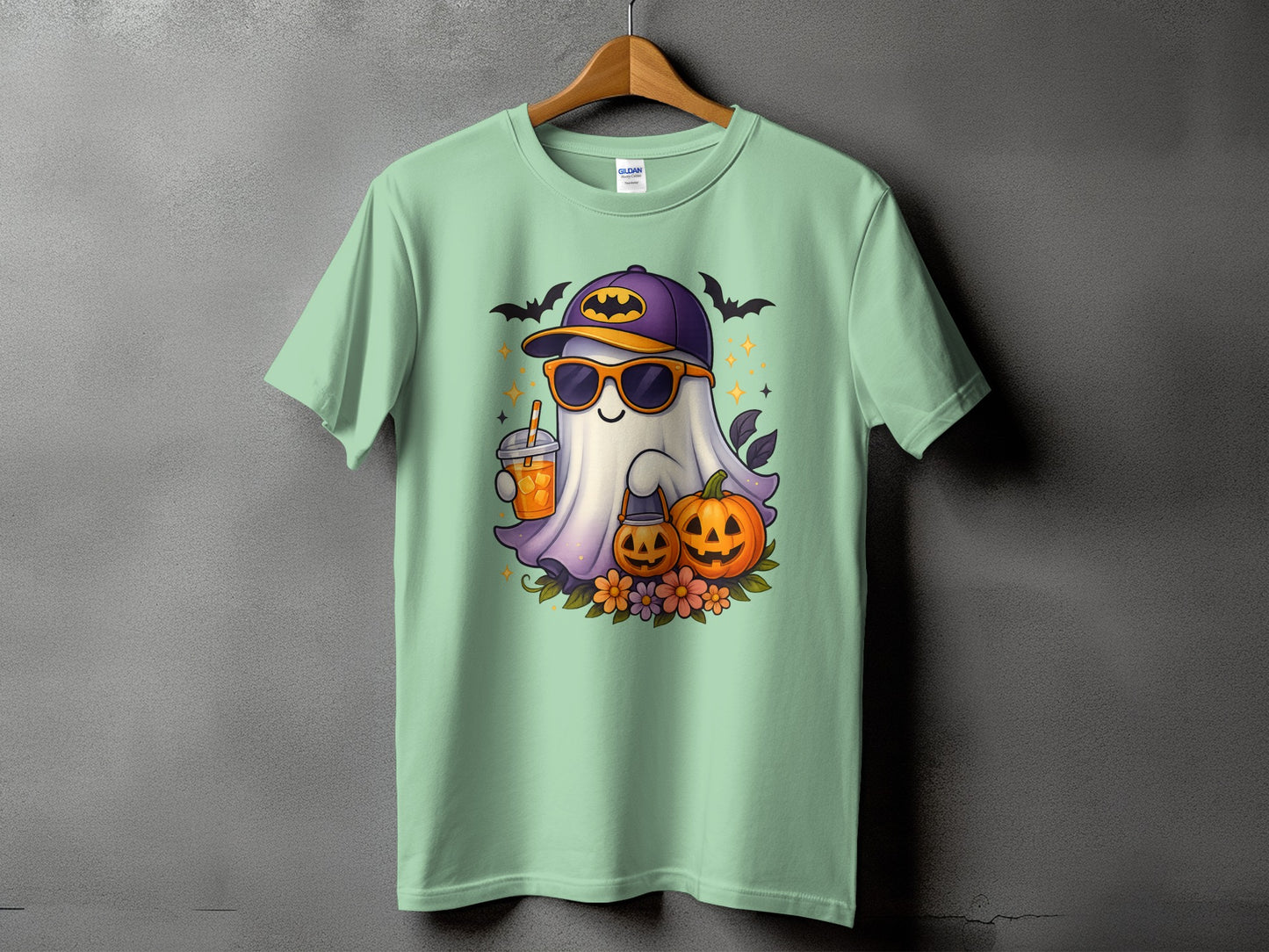 Ghost with sunglasses and drink, pumpkins, flowers, and bats on a mint t-shirt.