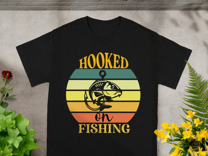 Black t-shirt with "Hooked on Fishing" graphic featuring a fish and retro sunset.