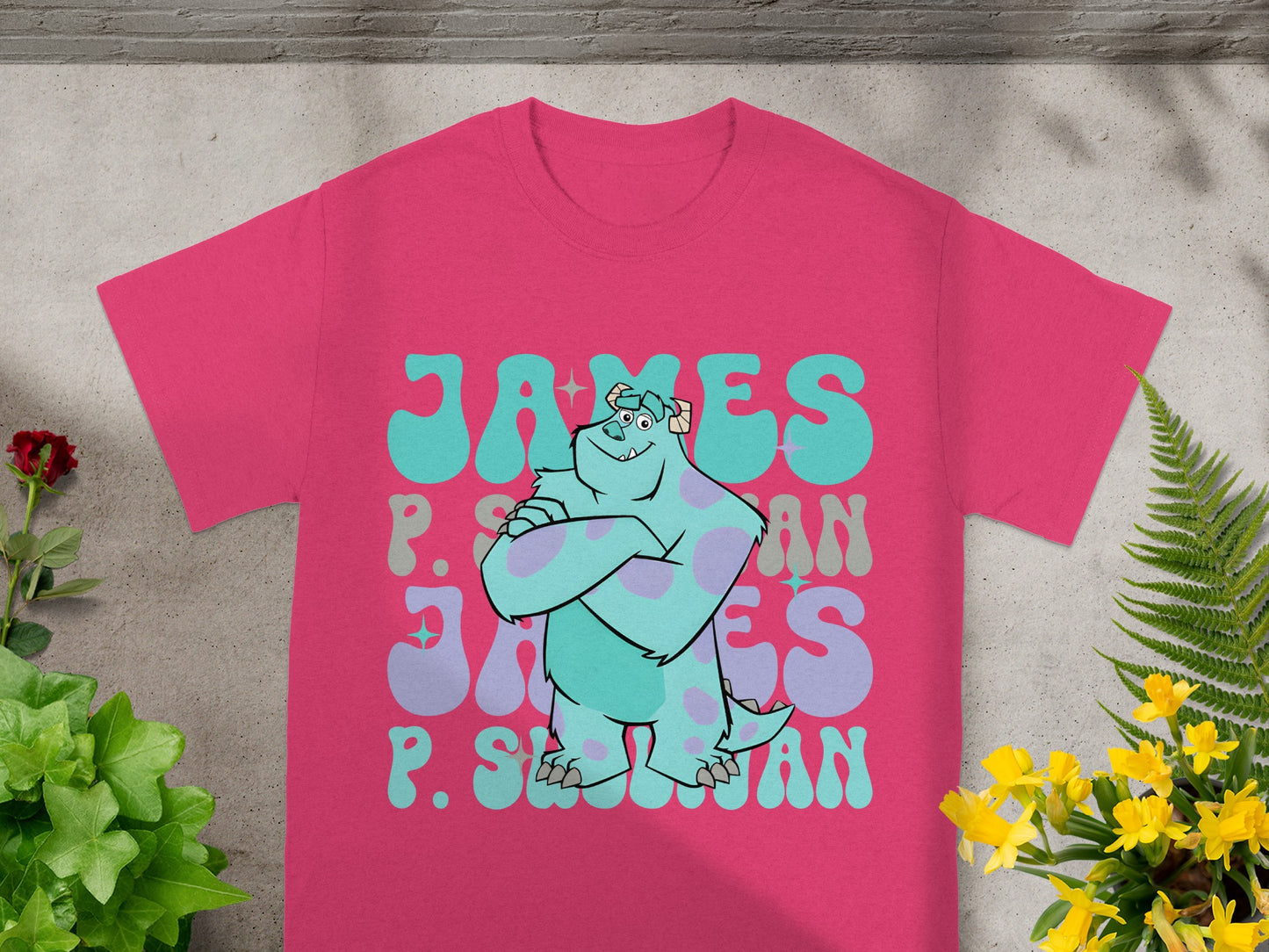 James P. Sullivan monster graphic on a pink t-shirt with foliage.