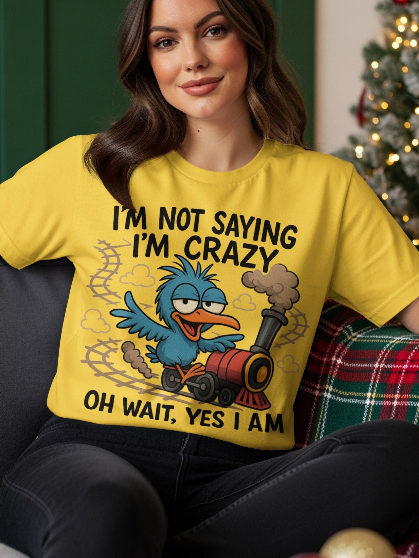 Yellow t-shirt with blue bird and train graphic, text "I'M NOT SAYING I'M CRAZY OH WAIT, YES I AM".