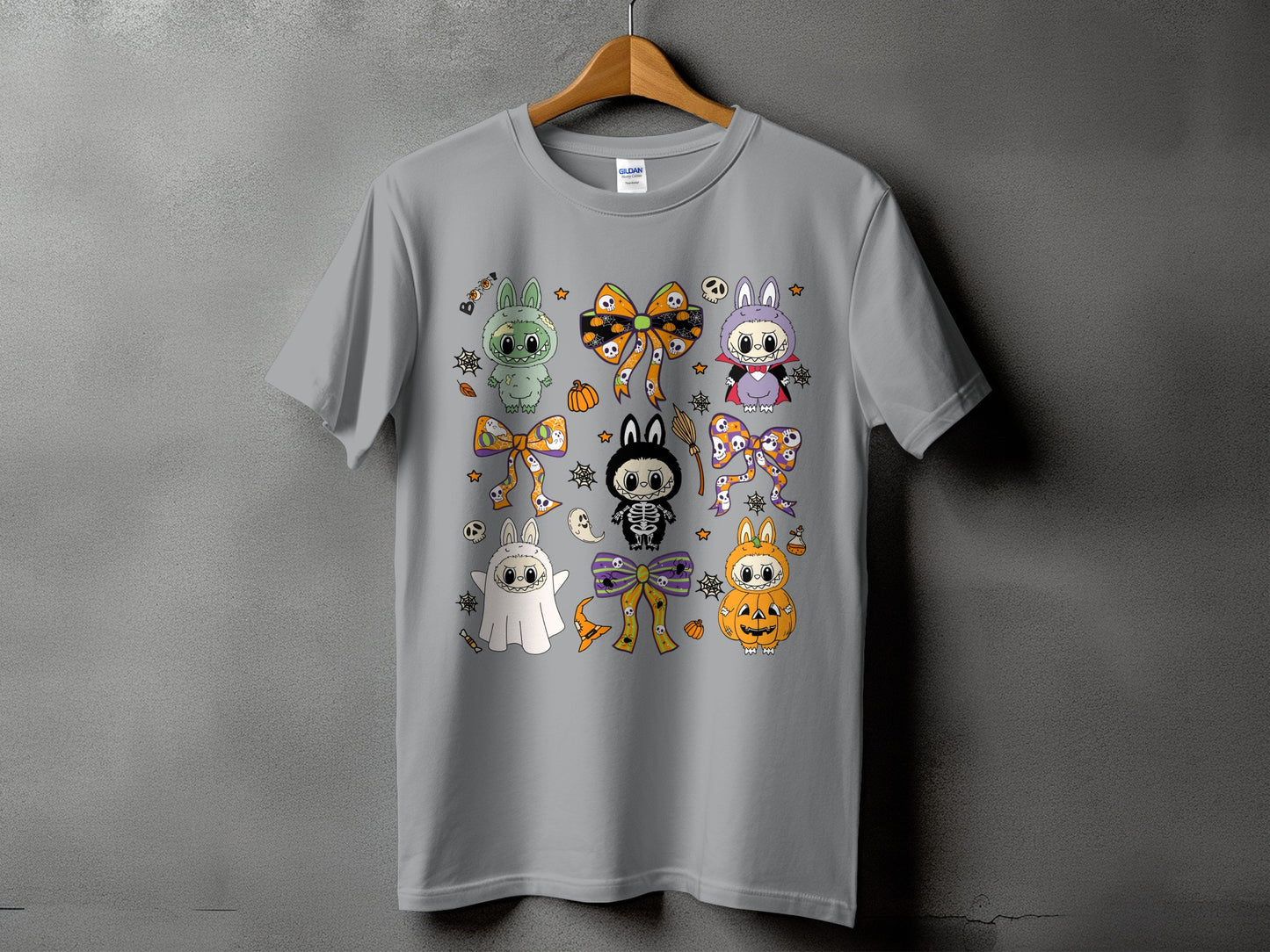 Grey t-shirt featuring a collection of cute, cartoon Halloween characters and bows.