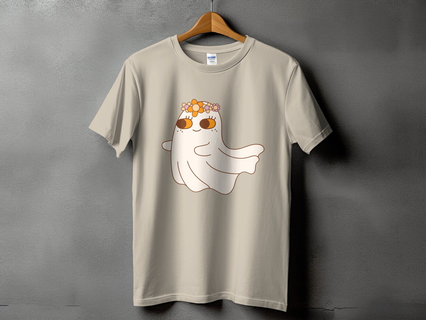 Light tan t-shirt with a cartoon ghost wearing a flower crown and large eyes.