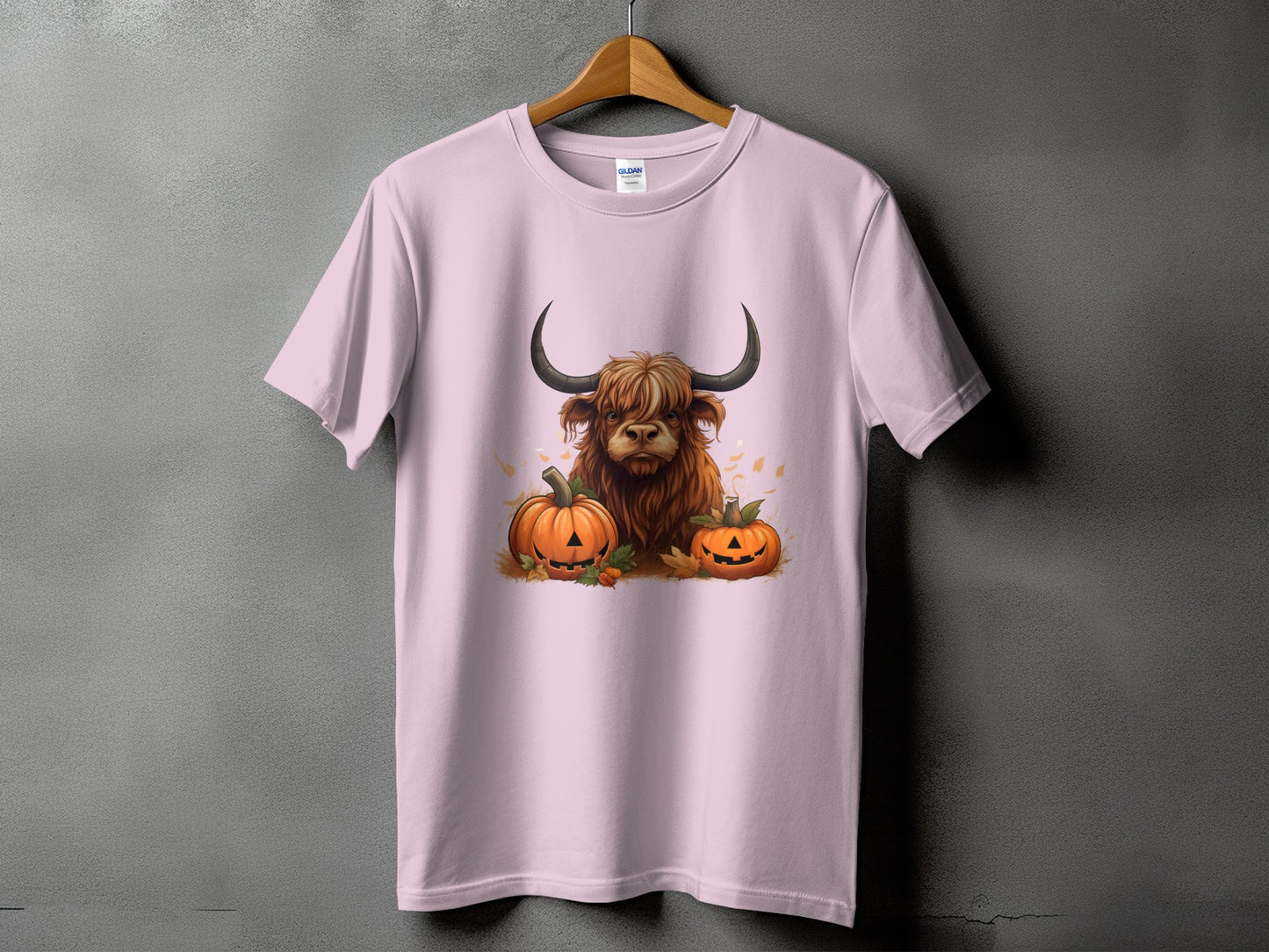 Pink t-shirt with Highland cow and jack-o'-lanterns graphic.