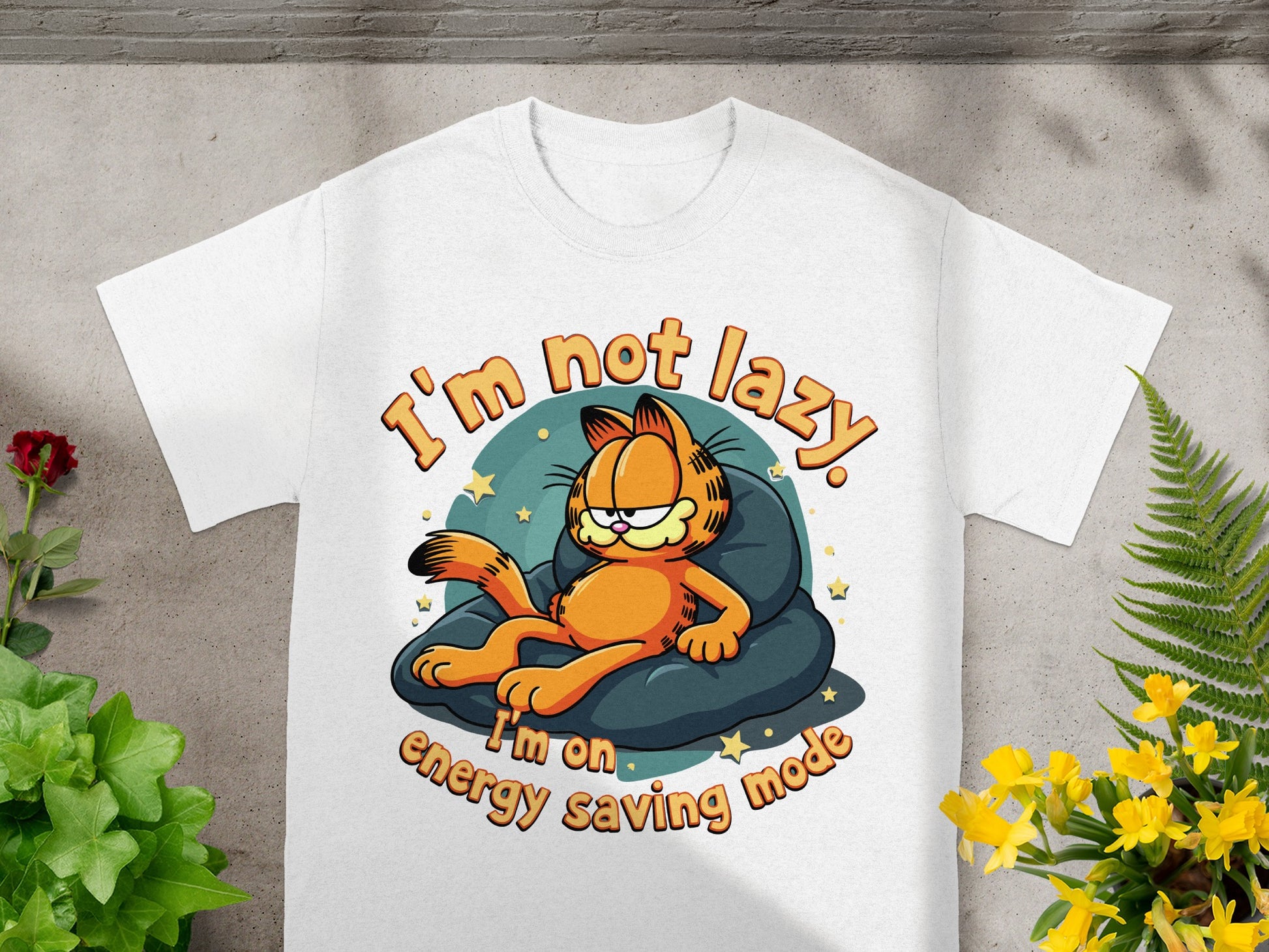 White t-shirt with Garfield lying on a pillow, text "I'm not lazy. I'm on energy saving mode."