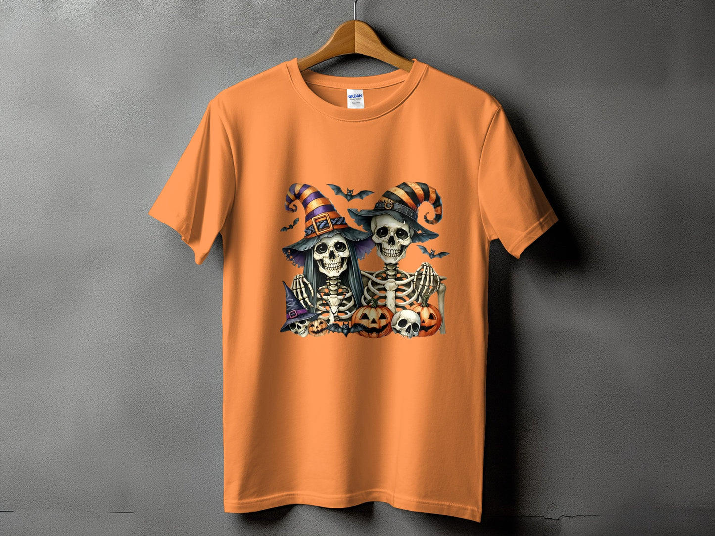 Halloween t-shirt with two skeleton couple wearing witch hats and pumpkins.