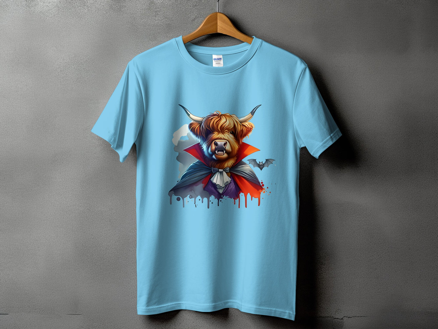 Light blue t-shirt with highland cow dressed as a vampire and a bat graphic.