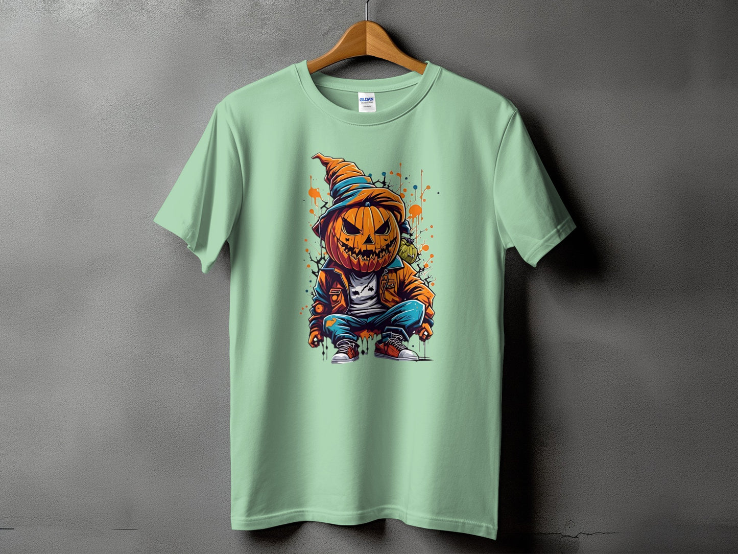 Light green t-shirt with a cartoon pumpkin character wearing a hat and jacket.