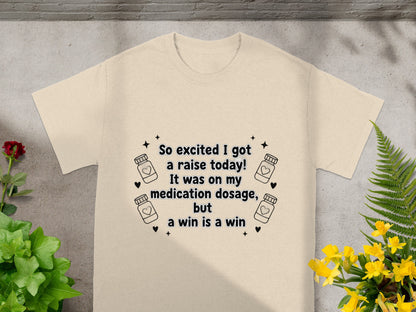 T-shirt with text: "So excited I got a raise today! It was on my medication dosage, but a win is a win."