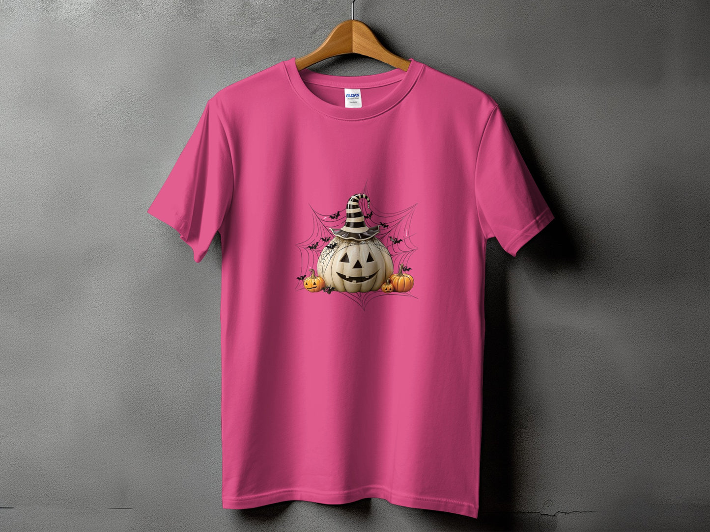 Pink t-shirt with a Halloween graphic of a pumpkin wearing a witch hat.