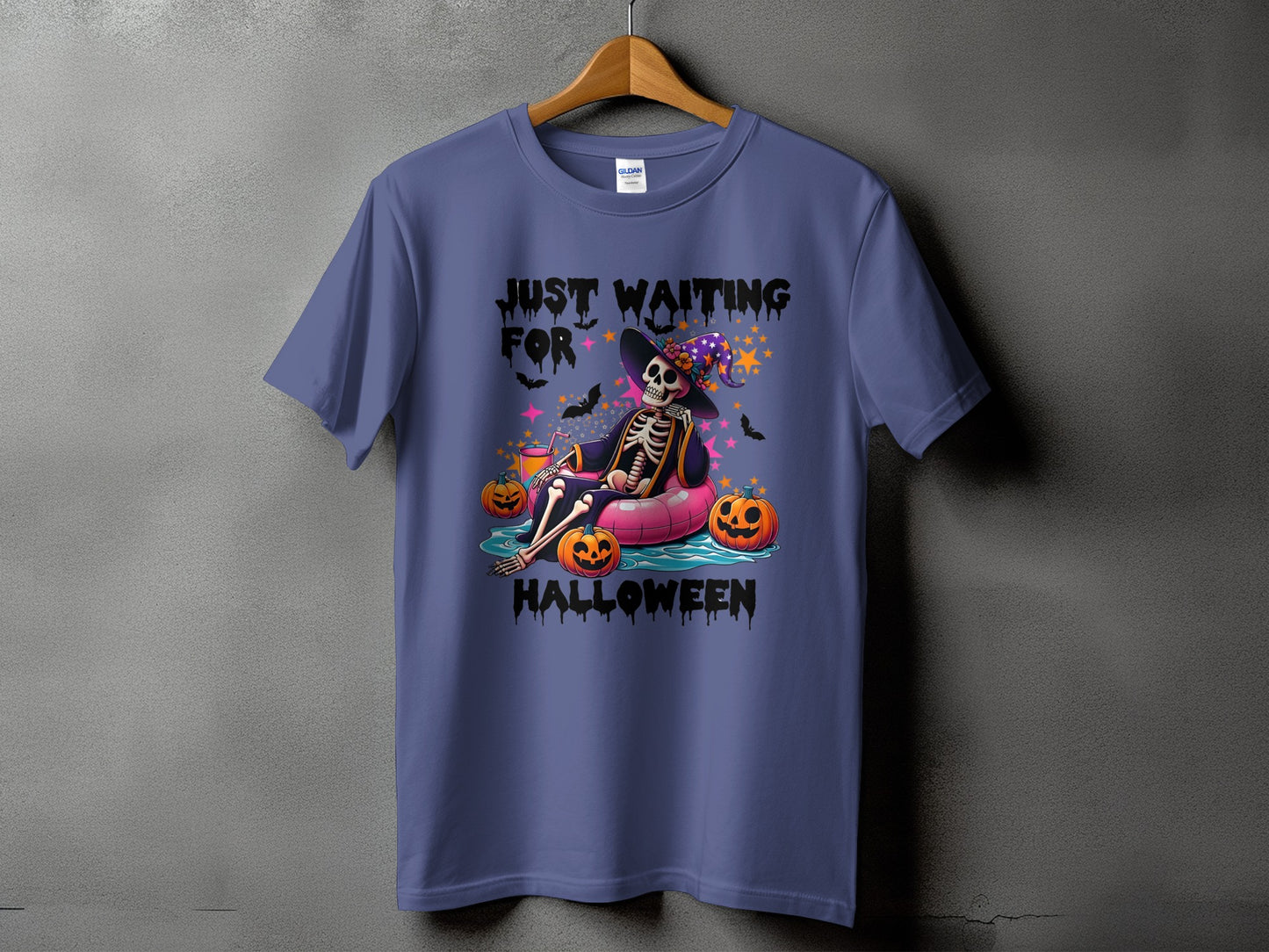 Purple t-shirt with skeleton on inner tube, pumpkins, and text "Just Waiting For Halloween".