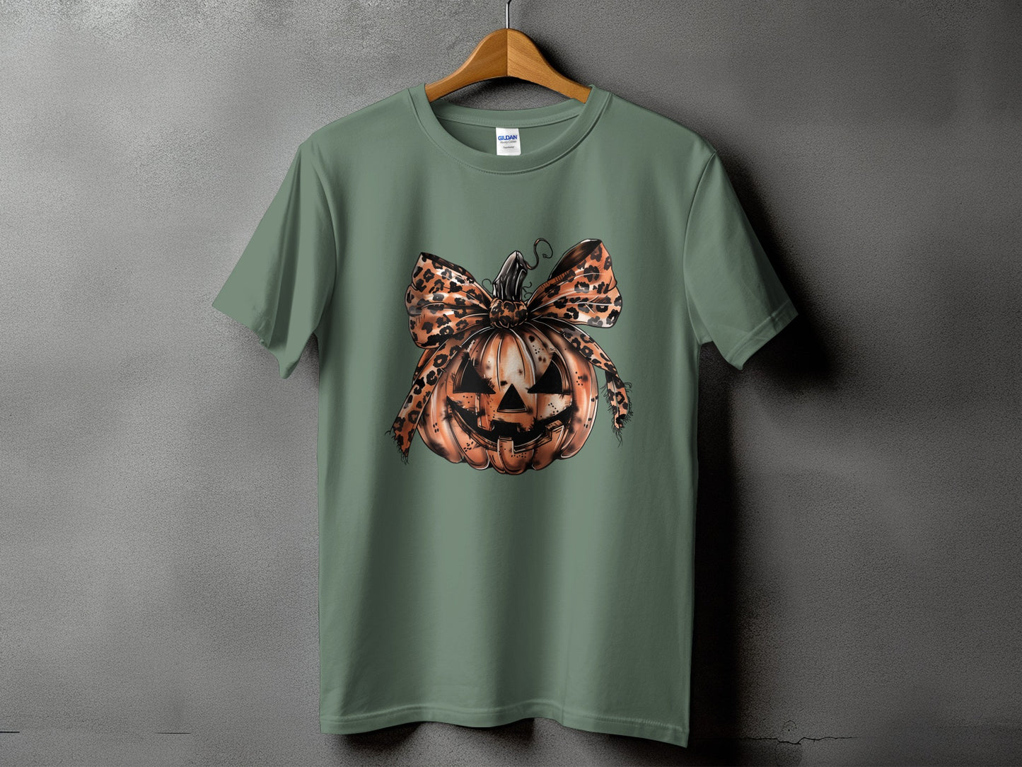 Green t-shirt with jack-o'-lantern graphic and leopard print bow.