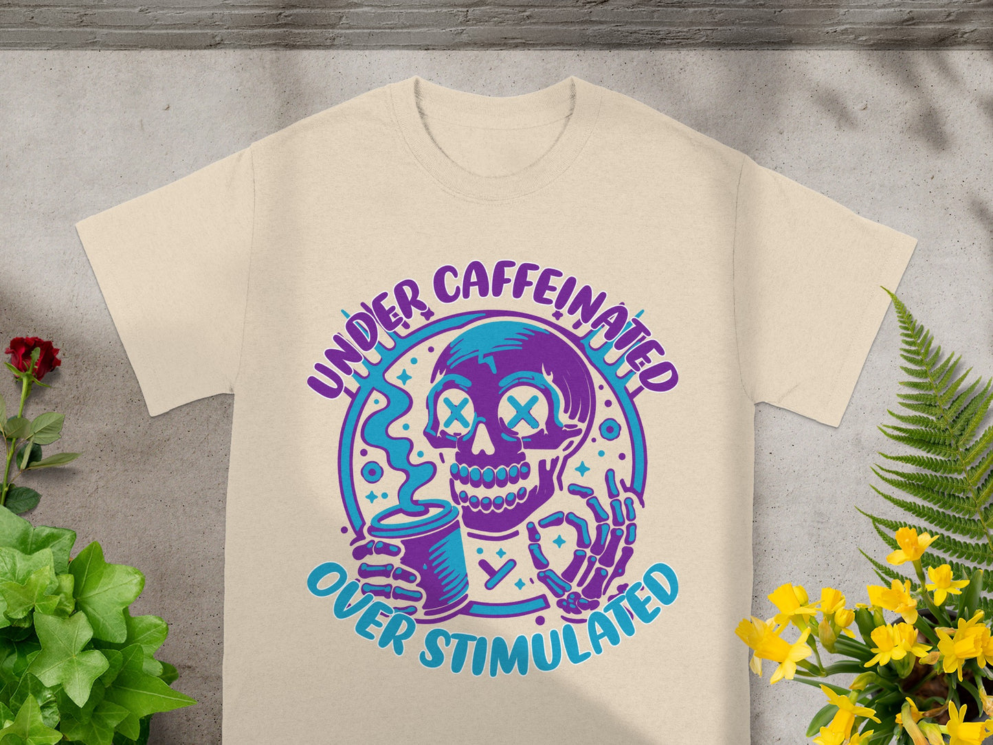 T-shirt with purple and blue skull holding coffee, text "Under Caffeinated Over Stimulated."