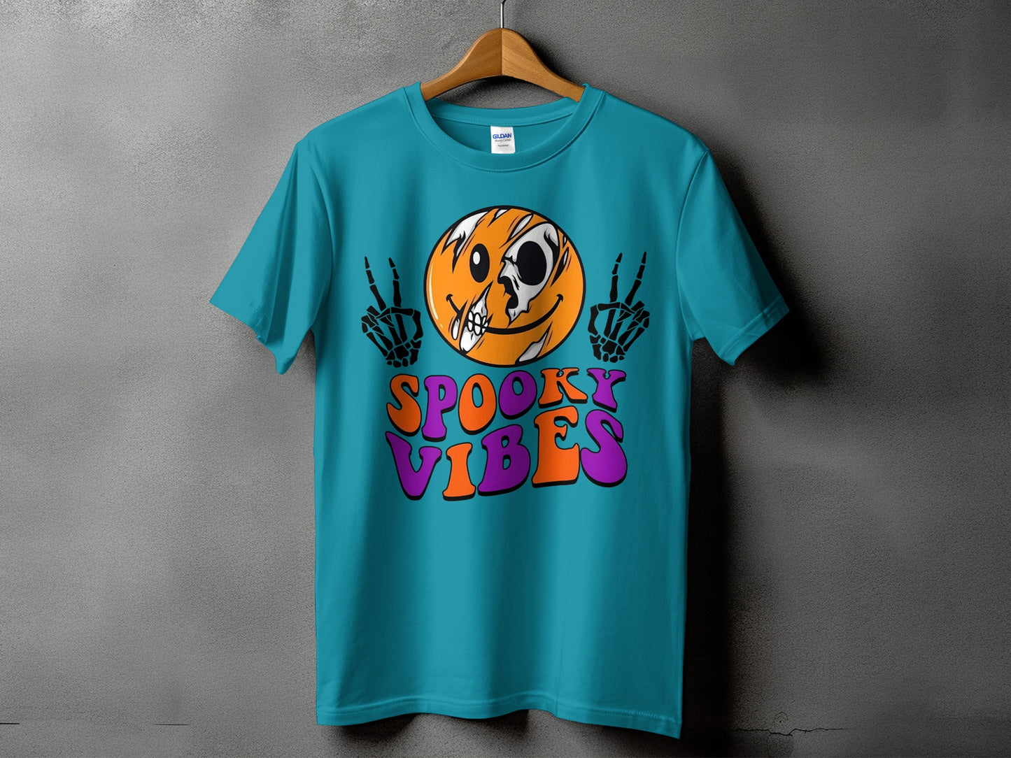 Teal t-shirt with cracked smiley face, skeleton hands, and text "SPOOKY VIBES".