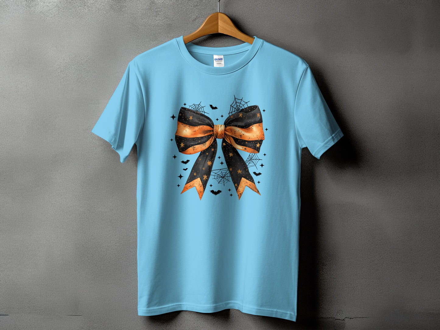 Light blue t-shirt with a black and orange Halloween bow graphic and bats.