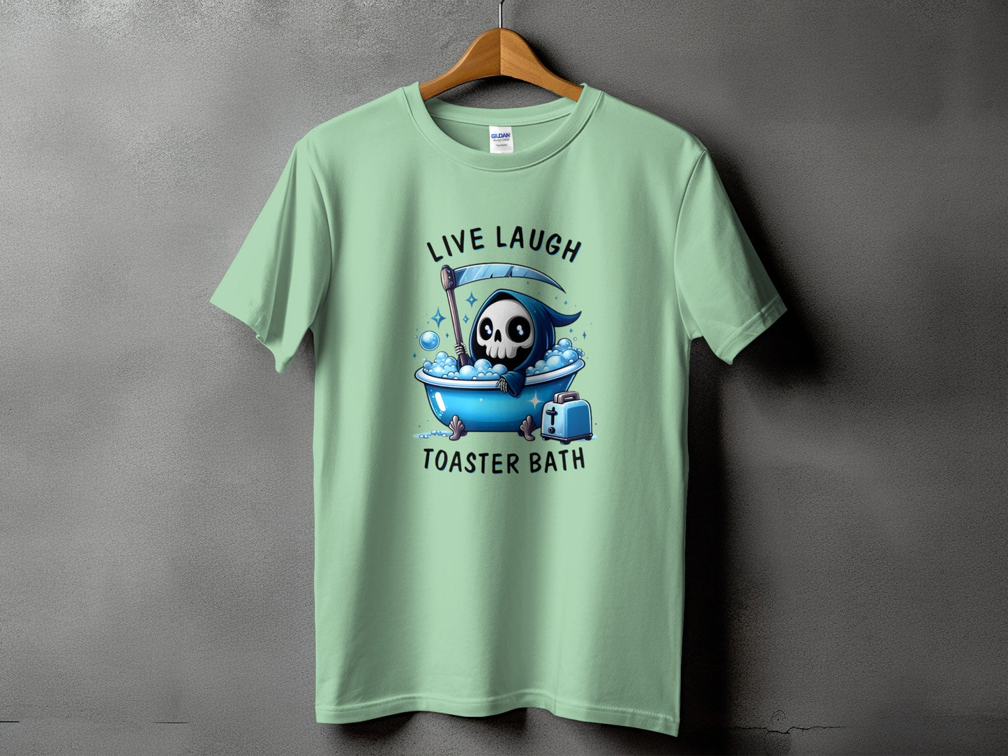 Light green t-shirt with Grim Reaper in bathtub and text "Live Laugh Toaster Bath".