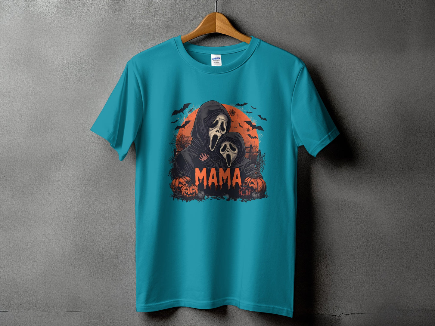 Teal t-shirt with horror-themed graphic featuring "Mama" and two figures in ghost masks.
