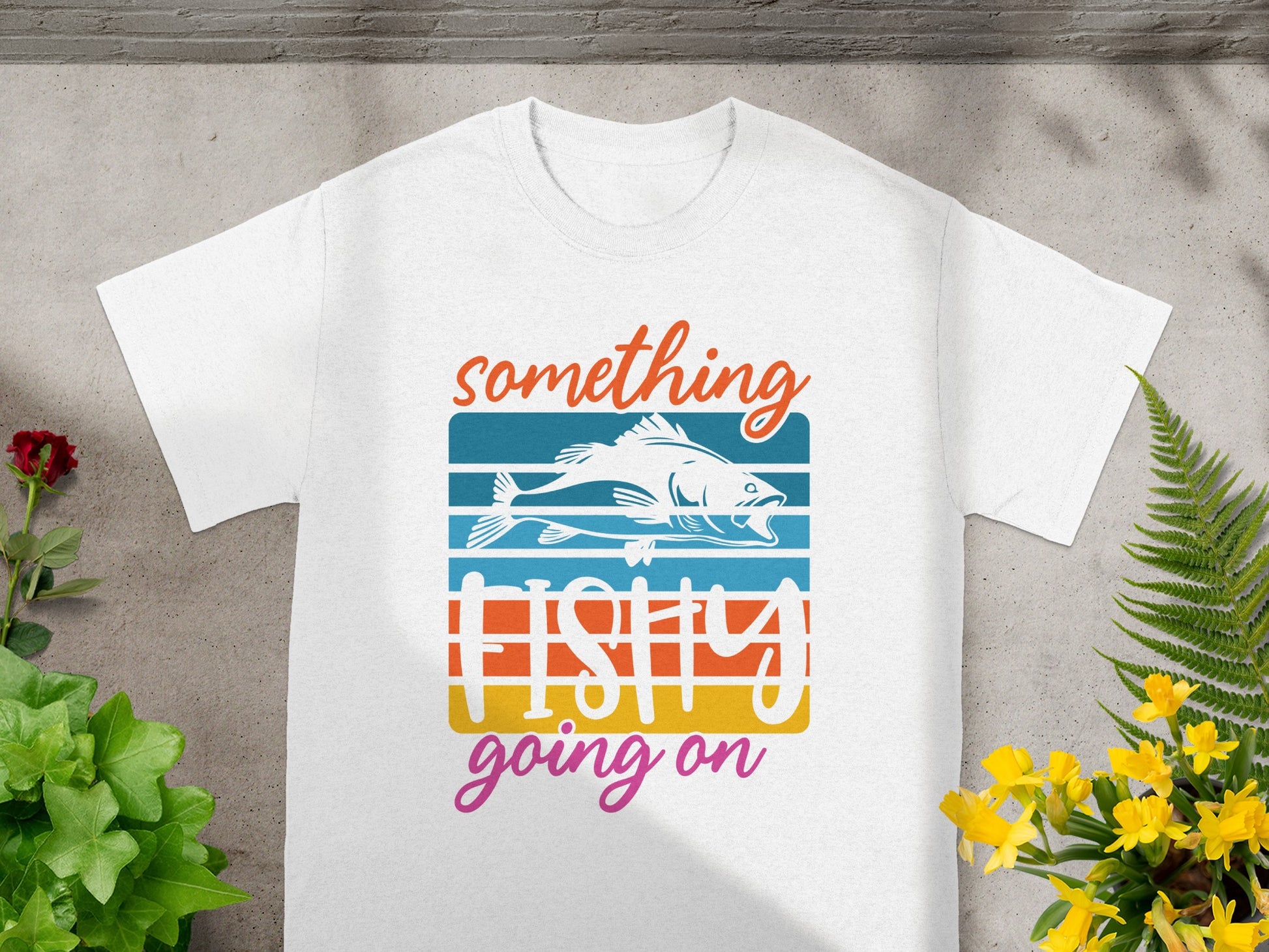 White t-shirt with fish graphic and text "something fishy going on."