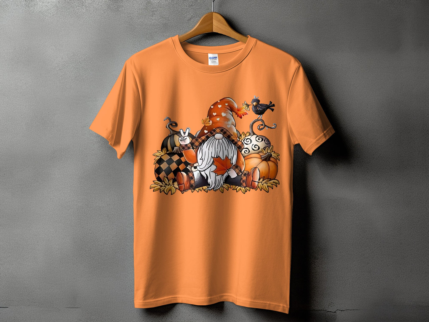 Gnome with pumpkins and a blackbird design on an orange t-shirt.